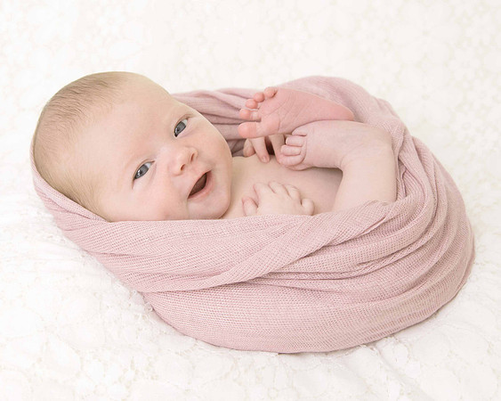 Newborn baby awake wrapped on beanbag.